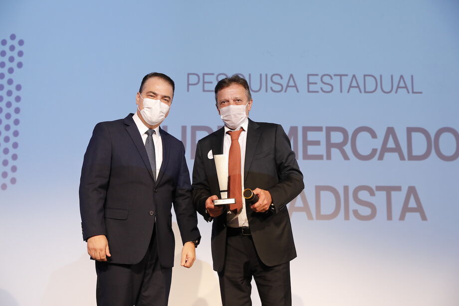 Adriano Araldi, diretor geral de mercado da NSC Comunicação, entrega o troféu Top Of Mind para João Pereira, vice-presidente comercial do Grupo Pereira