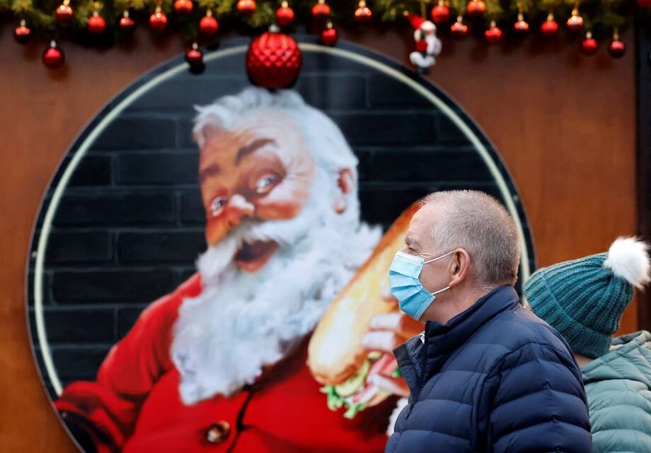 Em meio ao aumento de casos de covid-19 trazido pela variante Ômicron, homem faz compras de Natal usando máscara em Londres
