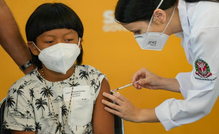Davi Seremramiwe Xavante, de 8 anos, foi a primeira criança brasileira vacinada contra a covid; entrega de mais doses pediátricas da Pfizer ao País sofreram atraso após tripulantes testarem positivo para o coronavírus
