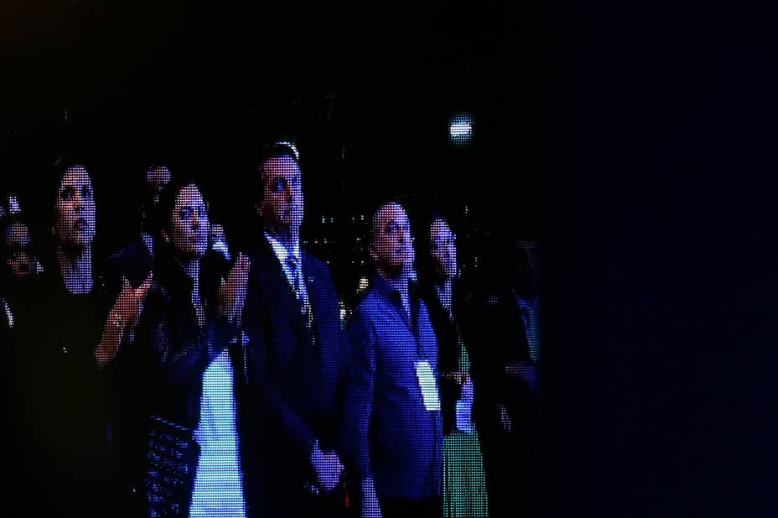 O presidente Jair Bolsonaro visto no telão do evento acompanhado da primeira dama, Michelle Bolsonaro e do ministro do Trabalho, Onyx Lorenzoni; no dia 16 de dezembro, Bolsonaro havia participado de um culto na Assembleia de Deus, também em Brasília.