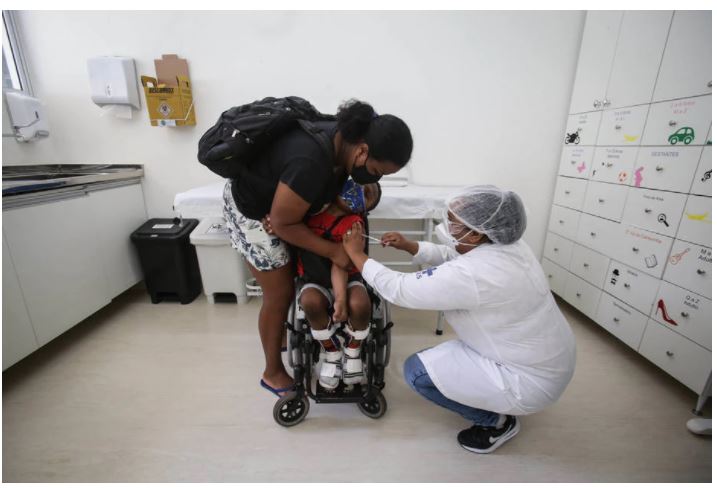 O garoto Kelvin, de 7 anos, é vacinado contra a covid na UBS Jardim Aeroporto, em São Paulo; cidade começou imunização de crianças com comorbidades e deficiência