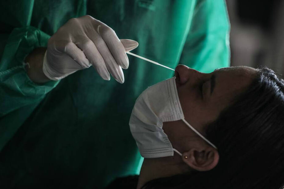 Paciente é submetida a teste de covid-19; após explosão de casos da Ômicron, média de mortes por covid sobe 566% no Brasil