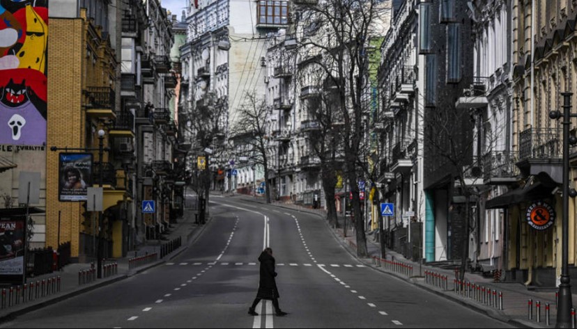 Pedestre atravessa uma rua vazia no centro de Kiev, na Ucrânia. Autoridades endureceram as ordens de toque de recolher na cidade enquanto as forças russas pressionam para capturar a capital do país
