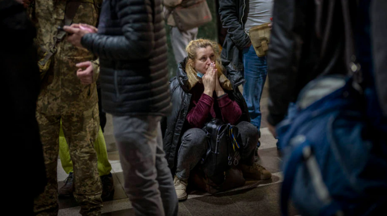 Mulher reage à situação na Ucrânia enquanto aguarda um trem partir, em Kiev, na Ucrânia.
