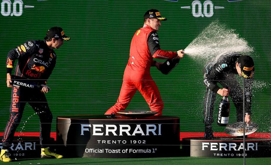 Charles Leclerc comemora o titulo na Austrália ao lado do Sergio Perez e George Russel, segundo e terceiro lugar, respectivamente.