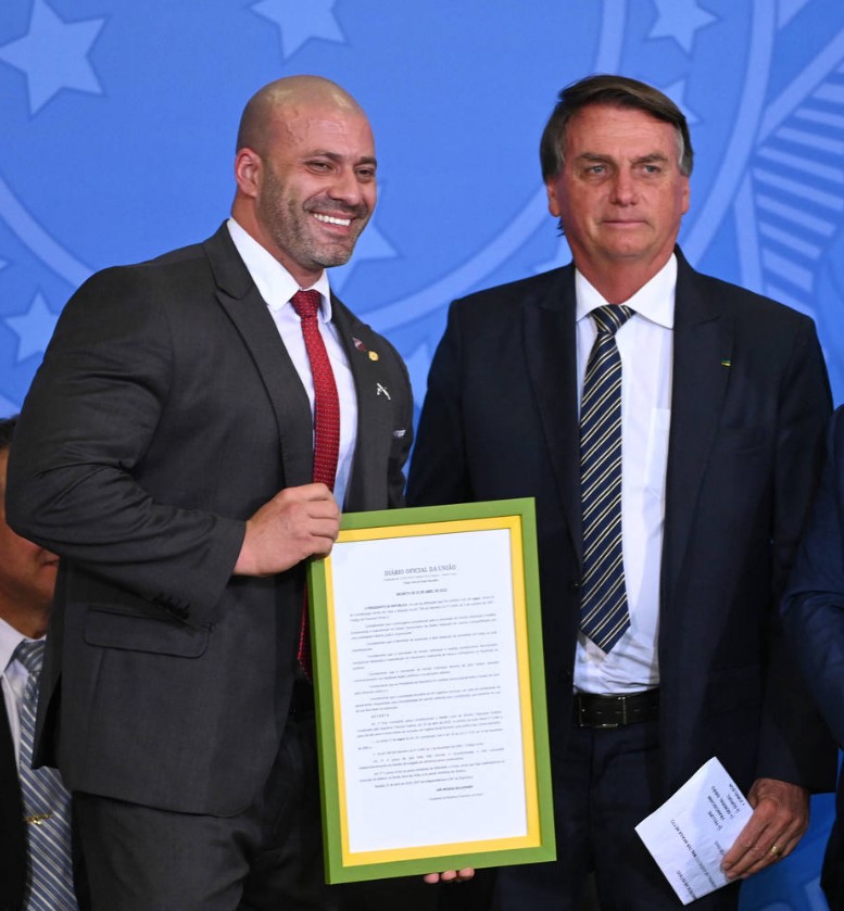 Bolsonaro e Daniel Silveira posam com cópia emoldurada do perdão presidencial, durante ato em defesa da liberdade de expressão no Palácio do Planalto, em Brasília, em 27 de abril de 2022