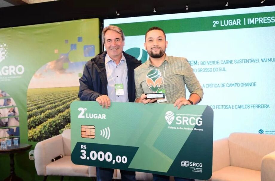 O jornalista Carlos Ferreira recebendo o troféu pela reportagem no jornal impresso