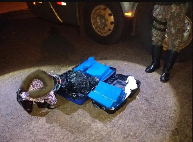 A garçonete confessou que carregava maconha nas suas malas. Ao todo, havia 26 tabletes da droga, que pesaram 24,1 kg
