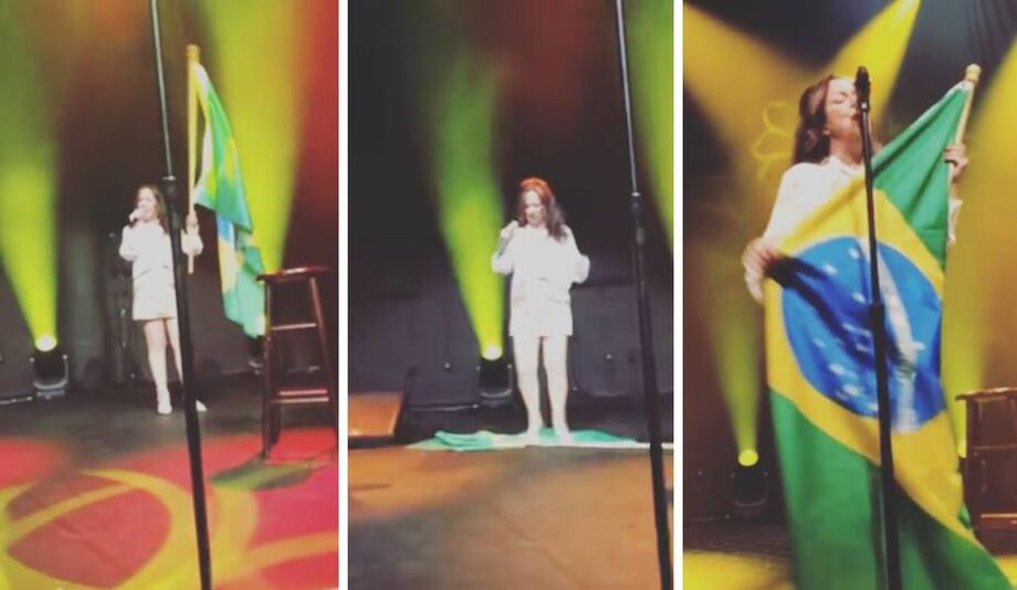 Momento em que a cantora Bebel Gilberto joga bandeira do Brasil no chão e pisa sobre ela durante show