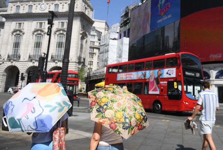 Pessoas usam sombrinhas para se proteger do sol durante onda de calor em Londres