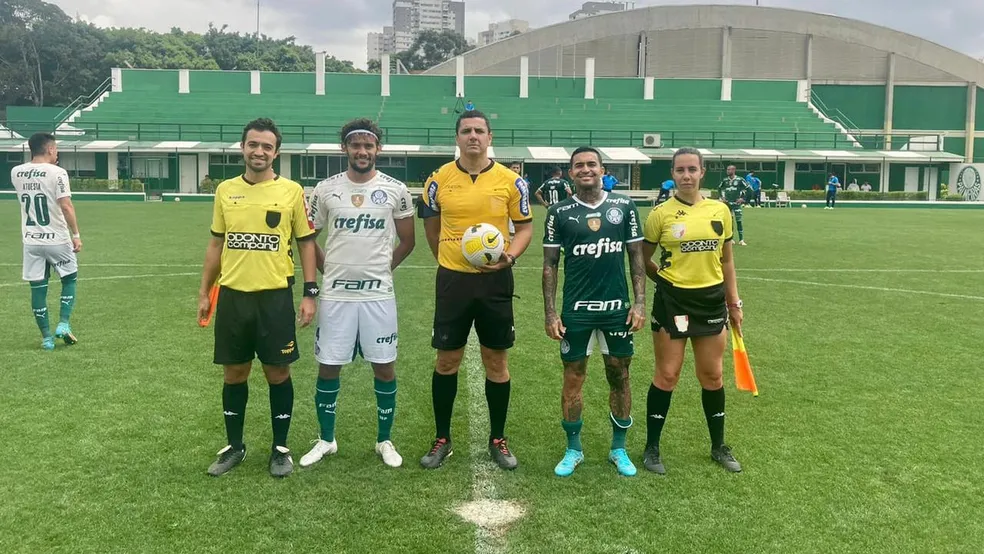Gustavo Scarpa, vestindo o uniforme 2, e Dudu, com o uniforme 1, posando ao lado da equipe de arbitragem