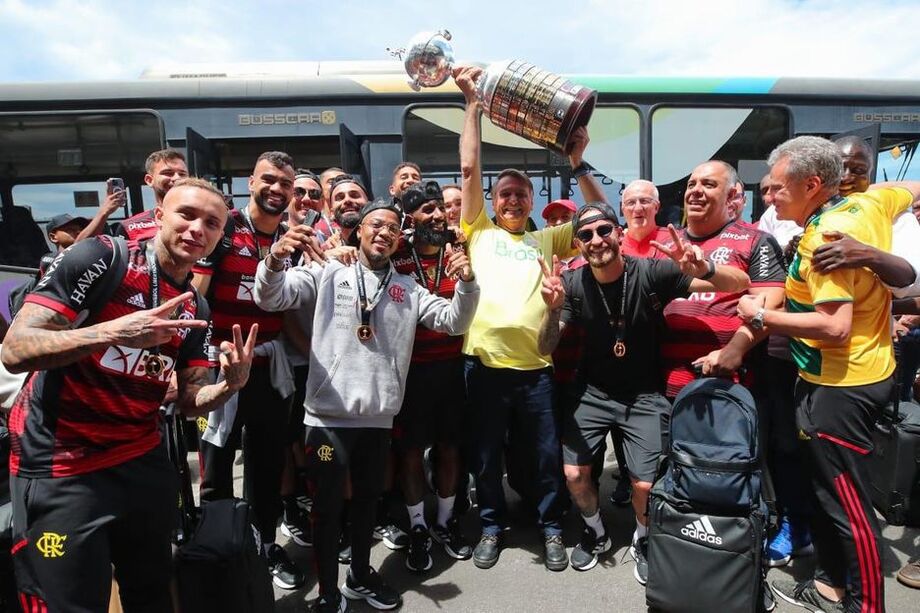 O presidente Jair Bolsonaro recebeu a delegação do Flamengo após a conquista do título da Libertadores e posou com jogadores segurando o troféu