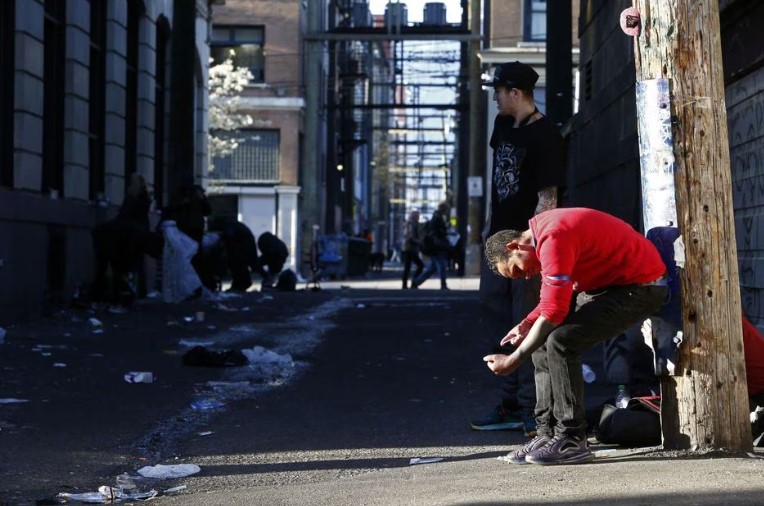 Homem injeta drogas em um beco no Downtown Eastside, em Vancouver, em abril de 2020