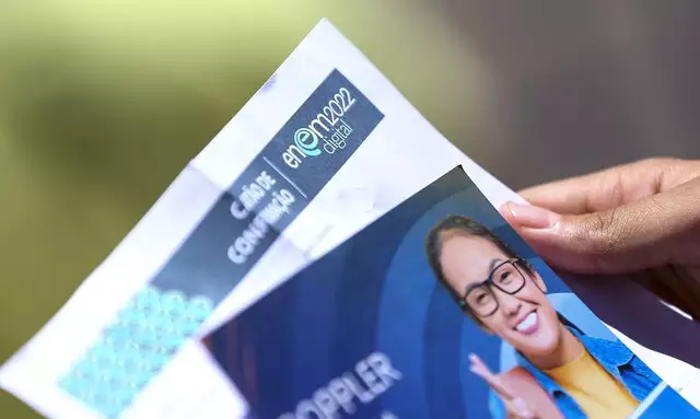 Estudante segura seu cartão de confirmação do Enem 2022.