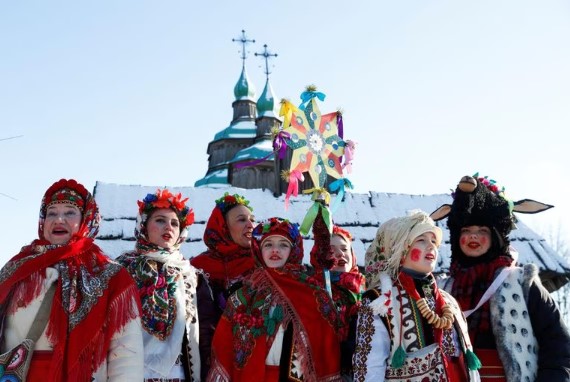 Ucranianas vestidas com trajes tradicionais cantam canções natalinas reunidas para celebrar o Natal ortodoxo no Museu Nacional de Arquitetura em Kiev, em 7 de janeiro de 2022