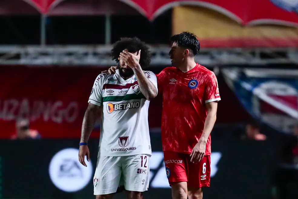 Marcelo, do Fluminense, fica desolado após choque com Luciano Sánchez e é consolado por Villalba, do Argentinos Juniors
