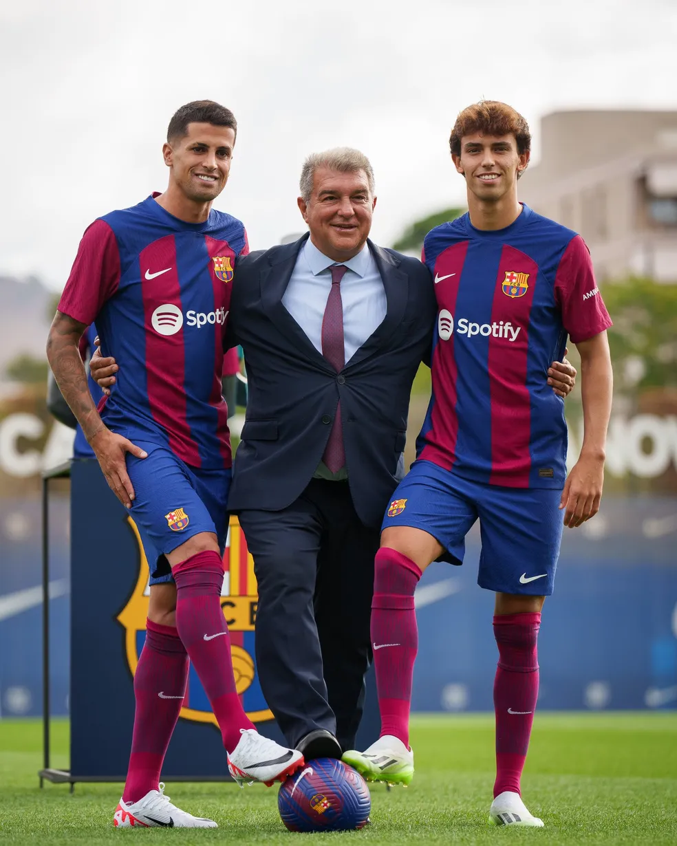 João Cancelo e João Félix posam com o presidente do Barcelona, Joan Laporta