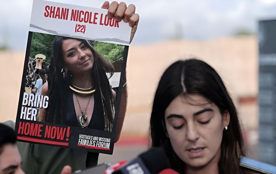 Prima de Shani Nicole Louk, fala aos jornalistas no dia 15 de outubro. Ao lado, é possível ver uma foto da jovem DJ que foi sequestrada pelo Hamas