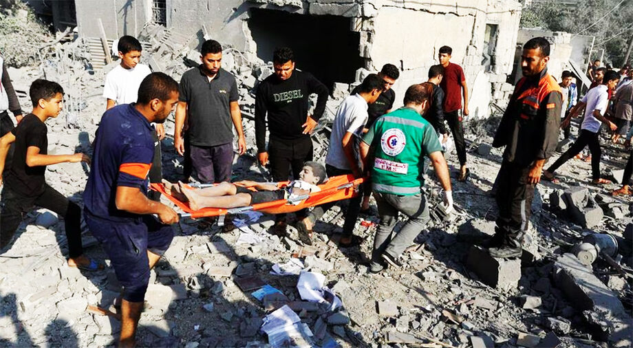 Palestinos carregam uma criança machucada após um ataque aéreo israelense na Faixa de Gaza