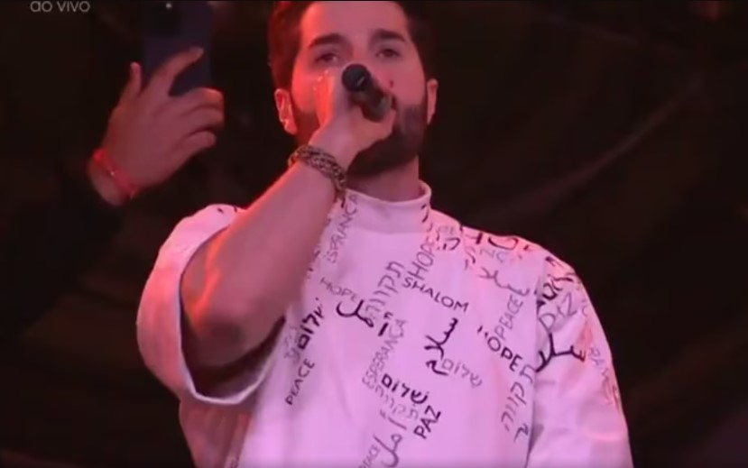 Alok usa camiseta branca com mensagem de paz em show de encerramento do Tomorrowland Brasil.