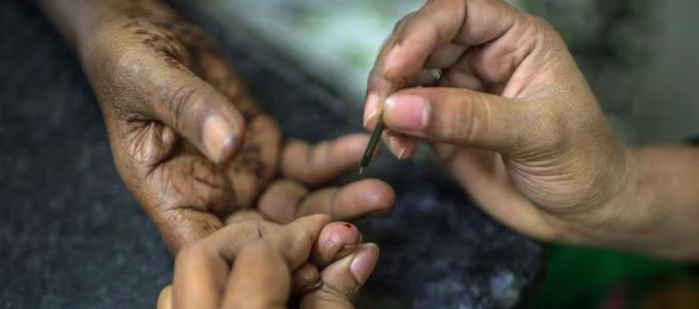 Enfermeira checa níveis de açúcar no sangue de paciente diabético