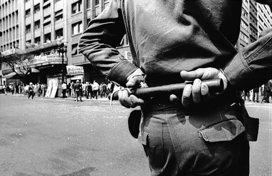 Policial observa manifestação do Movimento Estudantil contra a censura imposta pela ditadura militar, meses antes da aprovação do Ato Institucional nº5 (AI-5), que concedia poderes absolutos ao presidente durante o regime militar.