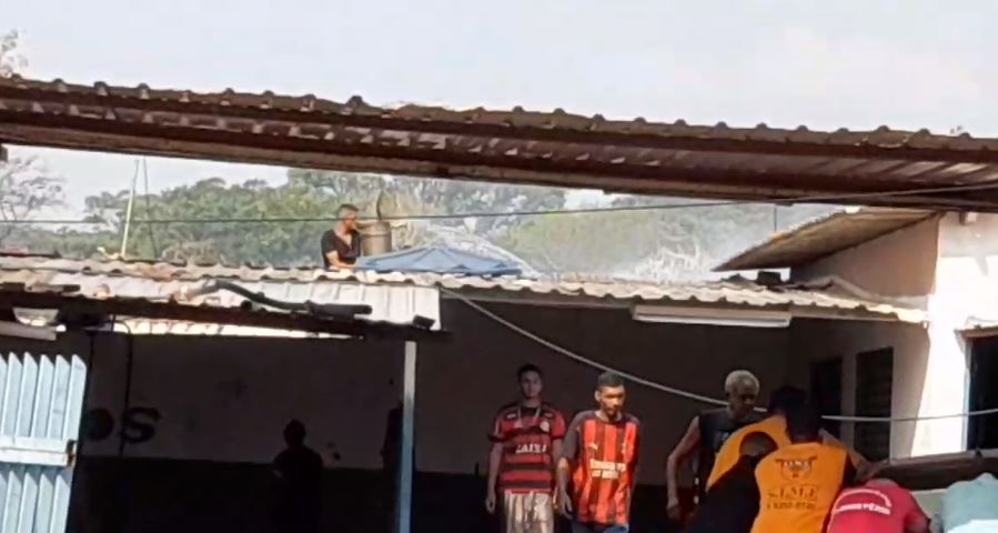 Morador jogando água da caixa d'água