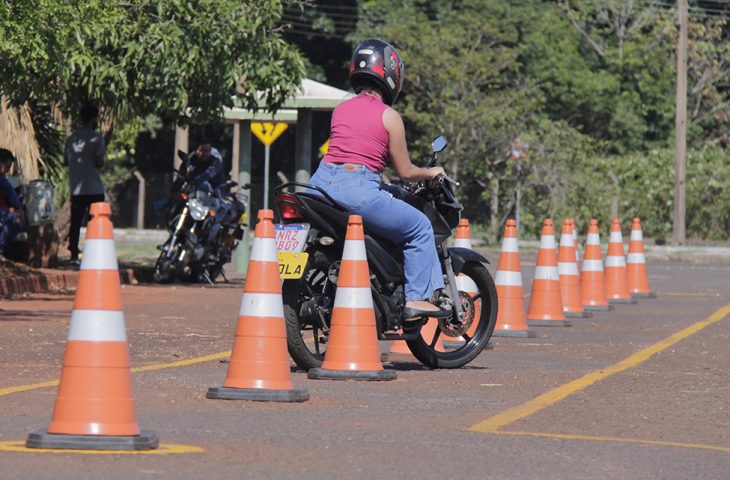 Mulher realiza o exame pratico para CNH de moto