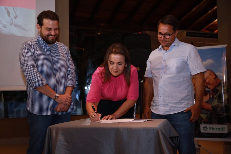 A prefeita Adriane Lopes assina sanção ao lado do vereador Claudio Serra e do presidente da Acrisul, Guilherme Bumlai
