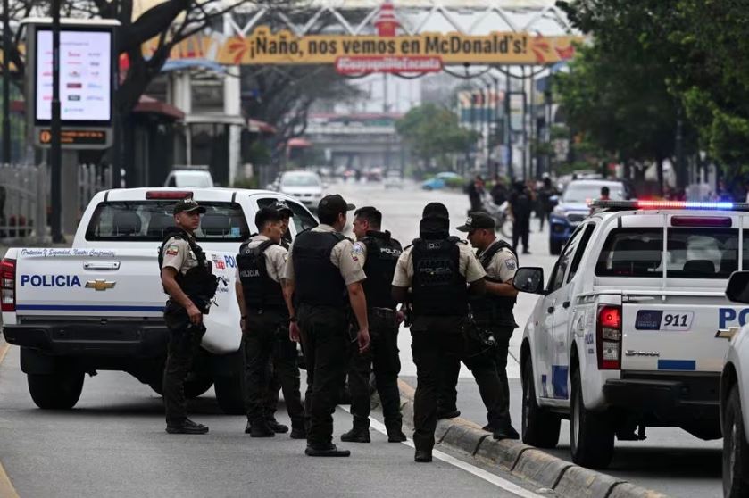 Membros da polícia equatoriana montam guarda perto do canal de televisão TC do Equador depois que homens armados não identificados invadiram o estúdio de televisão estatal ao vivo, em 9 de janeiro de 2024, em Guayaquil, Equador