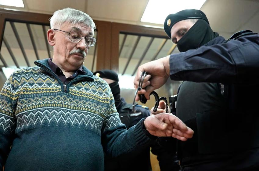 Policial algema Oleg Orlov, o ativista de direitos humanos e copresidente do grupo Memorial vencedor do Prêmio Nobel, após condenação a dois anos e meio de prisão