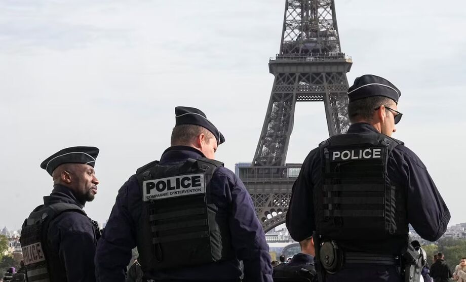 Policiais diante da torre Eiffel, em Paris; cinco caixões enroladas com a bandeira francesa foram encontrados diante do monumento
