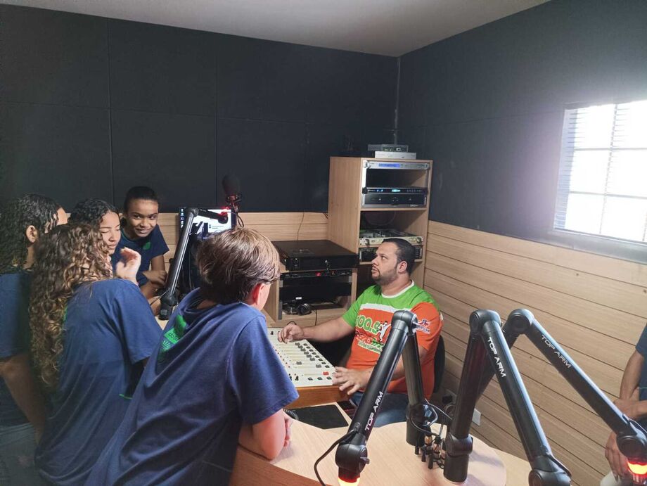 O locutor Allan Paiva mostra o estúdio para os alunos