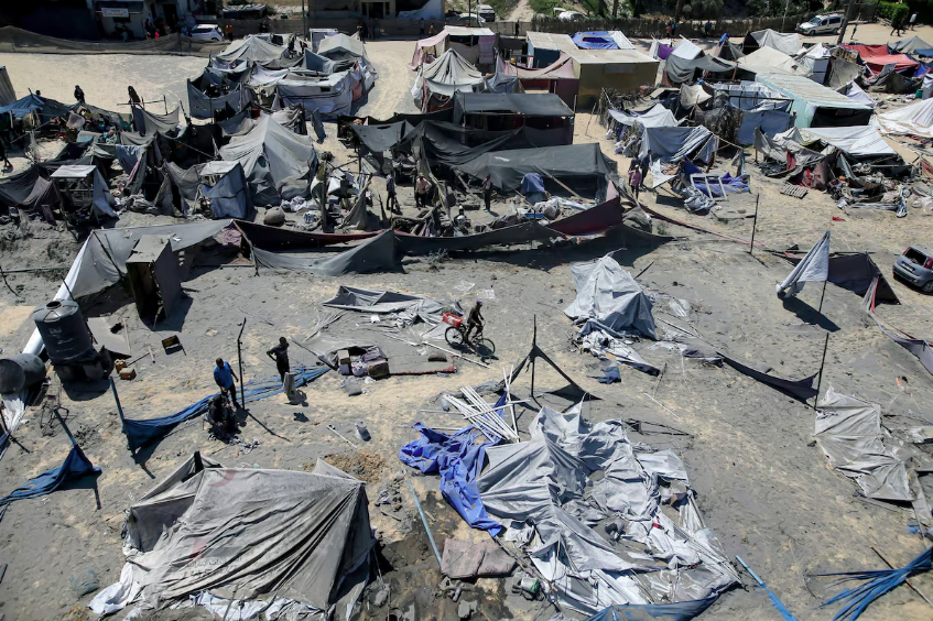 Palestinos inspecionam um local atingido por um bombardeio israelense em Khan Yunis, no centro da Faixa de Gaza.