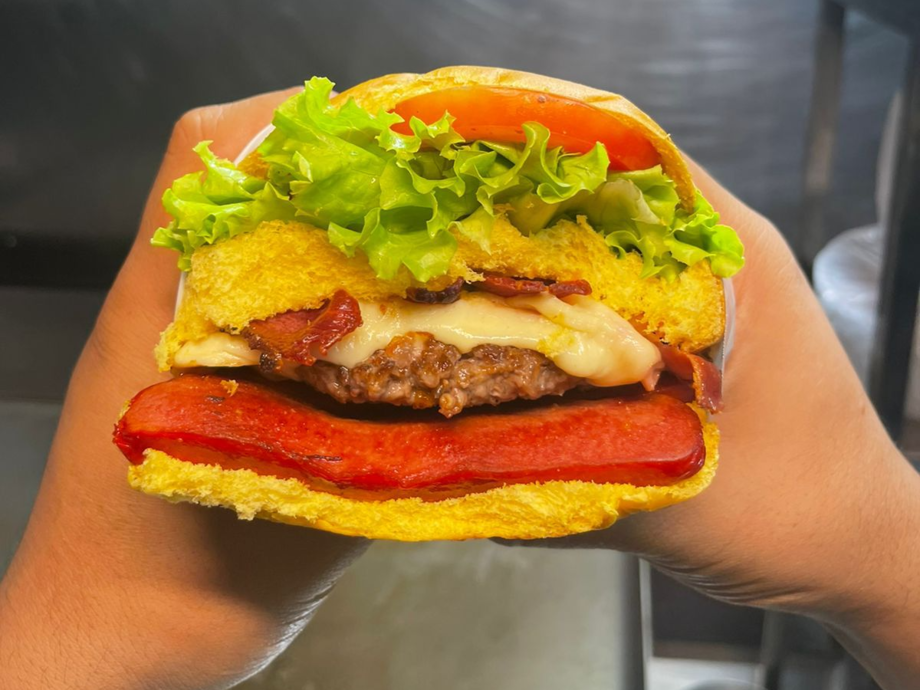 Hamburguer de metro já com dois ingredientes: Bacon e salsicha.
