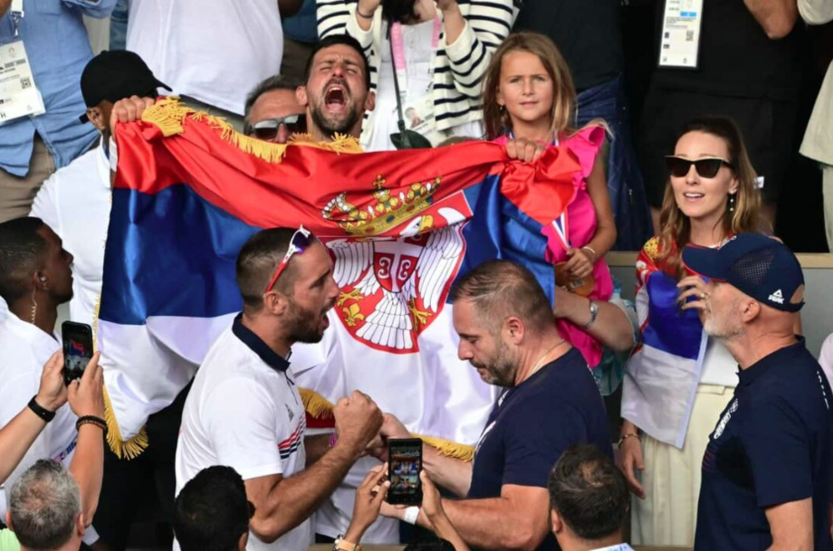 Empunhando a bandeira da Sérvia, Novak Djokovic comemora a vitória junto com a família