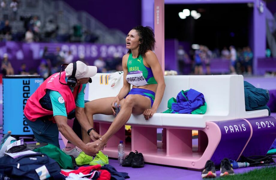 Valdileia Martins recebe atendimento após sofrer entorse durante salto no Stade de France, em Saint-Denis.