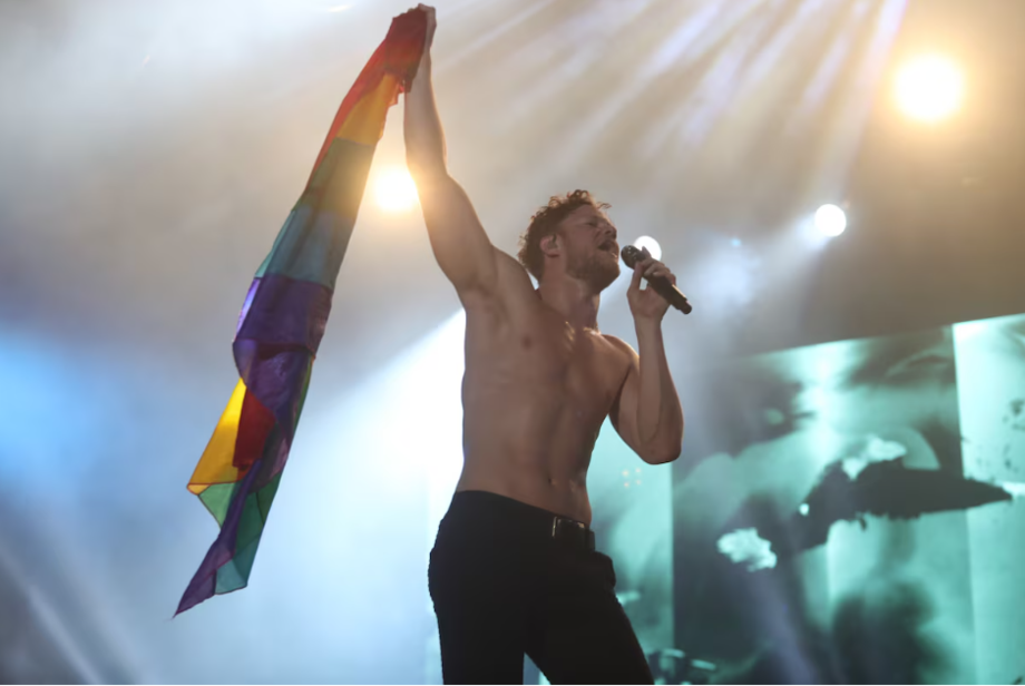 Dan Reynolds fica sem camisa em show.