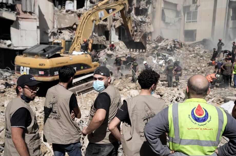 Serviços de emergência usam uma escavadeira para procurar corpos em um prédio atingido por um bombardeio israelense no subúrbio de Beirute, Líbano