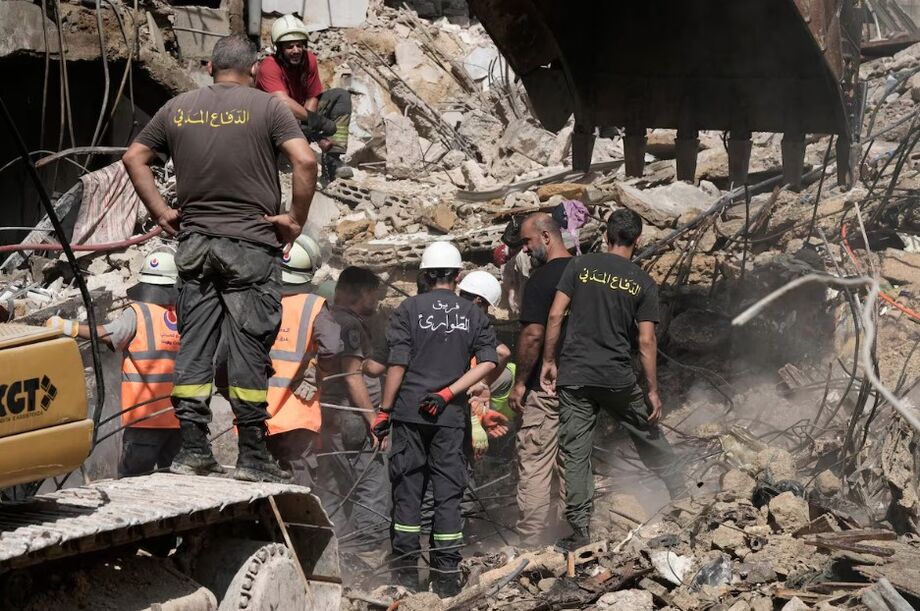Serviços de emergencia trabalham para retirar corpos e buscar por sobreviventes após um bombardeio israelense no subúrbio de Beirute, Líbano