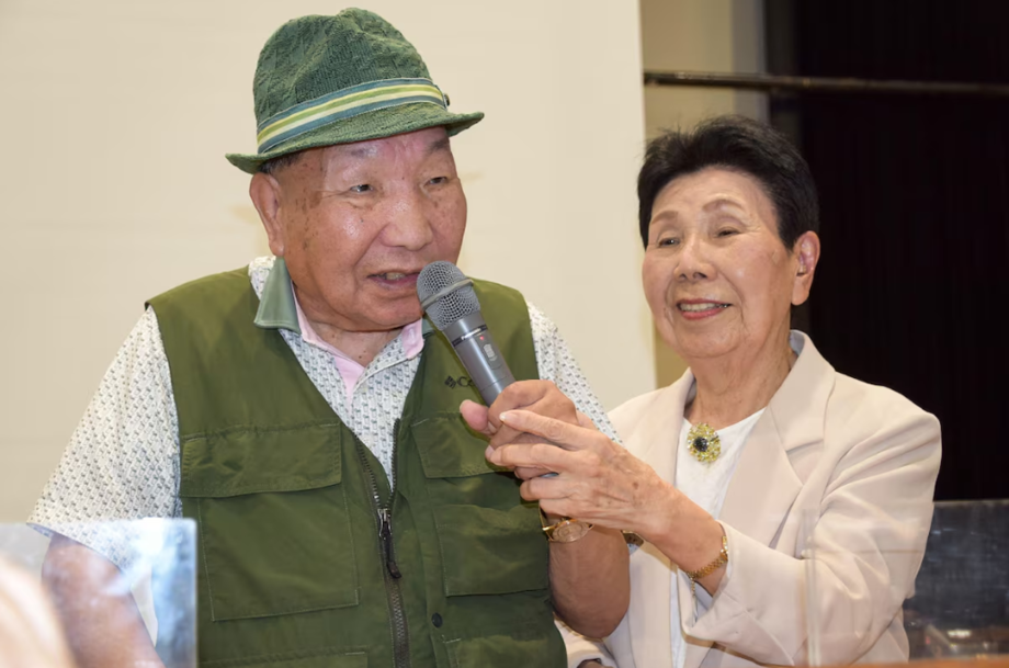 Esta foto, tirada em 29 de setembro de 2024, mostra Iwao Hakamada (à esquerda) falando enquanto sua irmã de 91 anos, Hideko (à direita), segura o microfone durante uma sessão de relato de julgamento realizada por apoiadores na cidade de Shizuoka, na proví