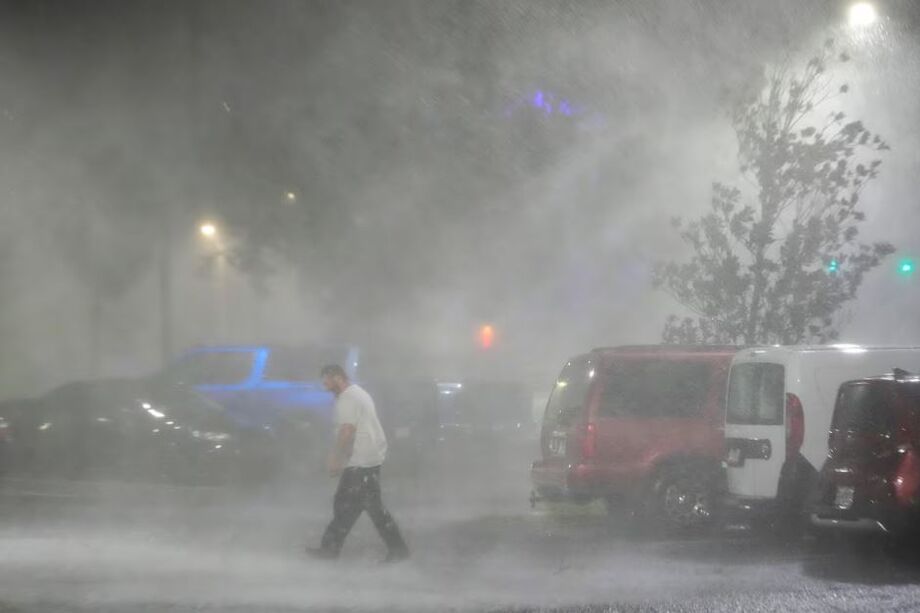 Homem anda em um estacionamento em meio ao furacão Milton, em Tampa, Flórida