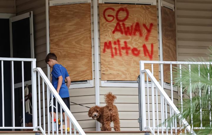 'Vá embora, Milton' está escrito em um tapume de proteção colocado nas janelas de uma casa em New Port Richey, Flórida, como prevenção ao furacão