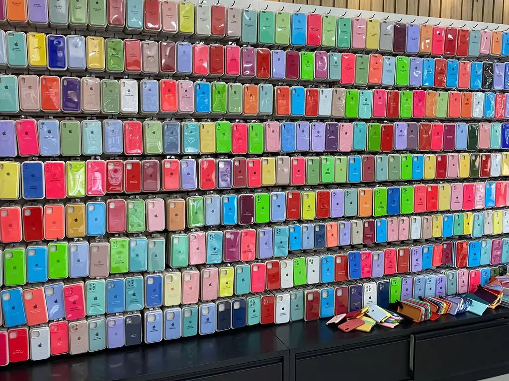 Parede exibe diversas capinhas de celular, supostamente da marca Apple, apreendidas durante operação contra produtos falsificados em Campo Grande