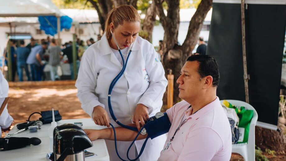 Enfermeira aferindo a pressão do servidor Alexandre