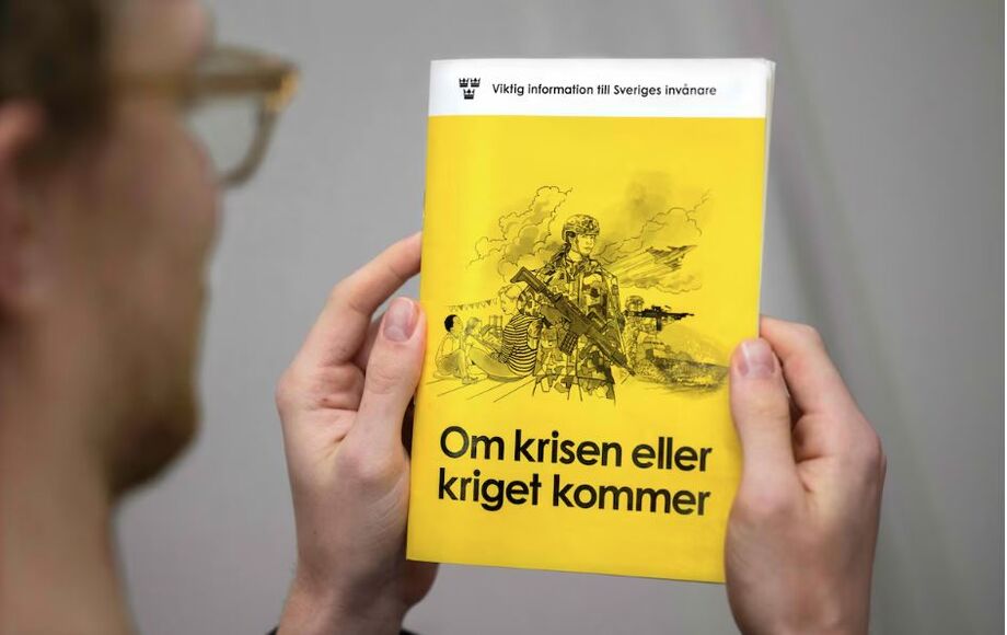 Um homem segura a nova versão do livreto de preparação 'If the crisis or war comes' ('Se a crise ou a guerra vier', em português), que será distribuído a famílias na Suécia.
