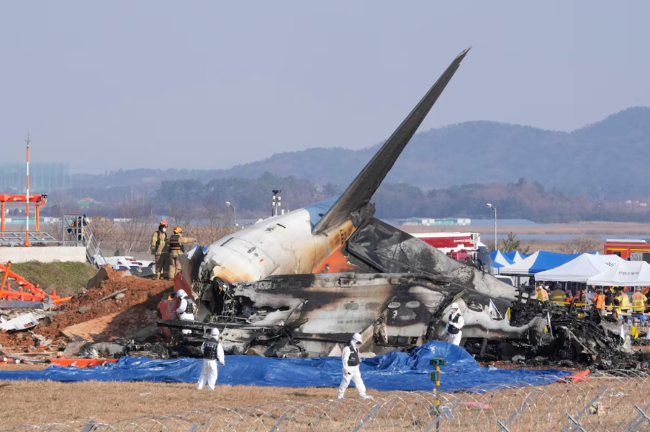 Equipes de resgate trabalham perto ao avião que colidiu contra um muro na Coreia do Sul neste domingo, 29.