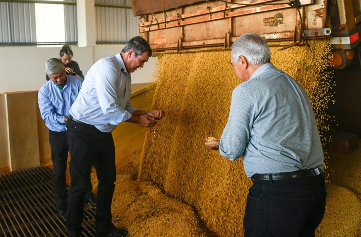 Governador Eduardo Riedel, presidente da Copasul Adroaldo Taguti e o ex-governador Reinaldo Azambuja (de costas) acompanham o início do processamento da soja no novo silo da Copasul, em Maracaju.