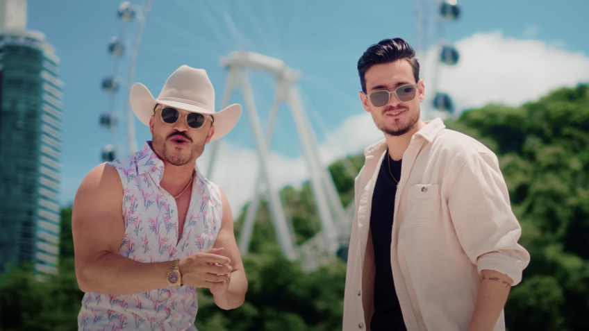 Brenno & Matheus no videoclipe de Descer pra BC, com cenário de Balneário Camboriú ao fundo, reforçando a imagem da cidade como destino turístico de destaque