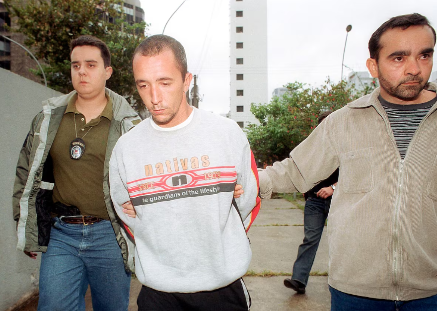 Cristian Cravinhos em 2002, a caminho de reconstituição do crime; naquele ano, segundo a Justiça, ele matou Marísia e Manfred von Richthofen, junto com o irmão e a namorada do irmão, Suzane.